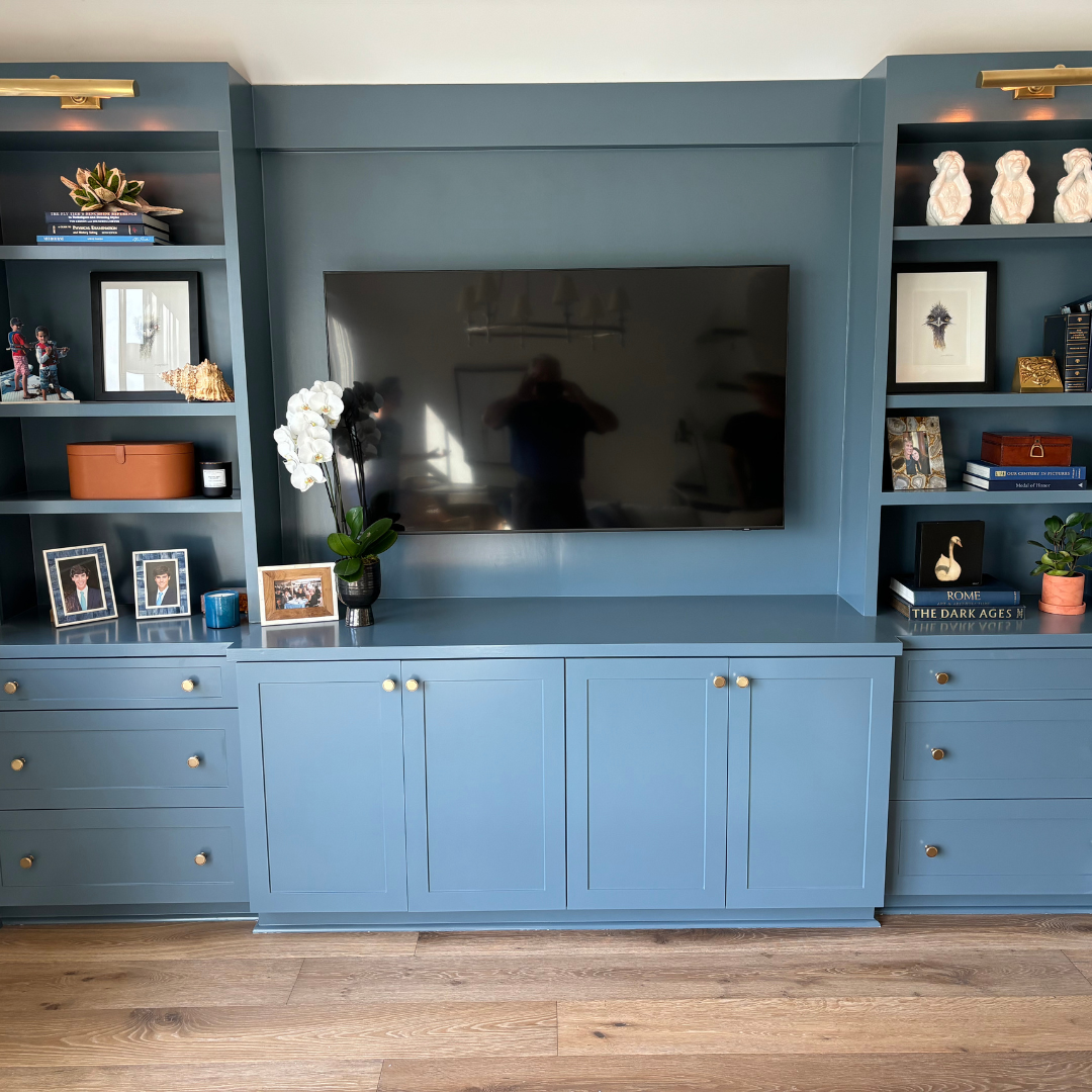 Custom, blue built-in cabinetry functioning as a media center.